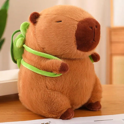 Close-up of the Capybara Dreams plush backpack toy in soft fabric with cute turtle design, showing the brown capybara plush with green straps and a small green turtle on its back.