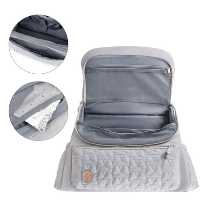The gray Cloudscape Diaper Backpack open, showcasing its organized interior with mesh pockets. Inset images provide a closer look at a zippered pocket and a mesh pocket containing a baby outfit.