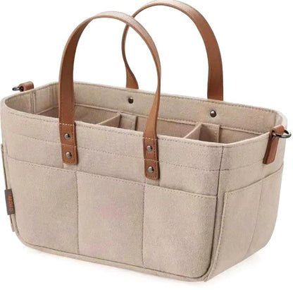 Beige Cloudscape Diaper Tote Bag made of structured felt with brown leather handles, featuring multiple internal compartments and external pockets, shown on a white background.