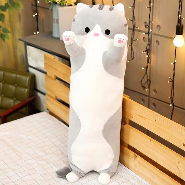 Long gray cat plush toy standing upright on a bed, featuring soft fabric and a huggable design, perfect as a cuddle buddy or decorative plush.