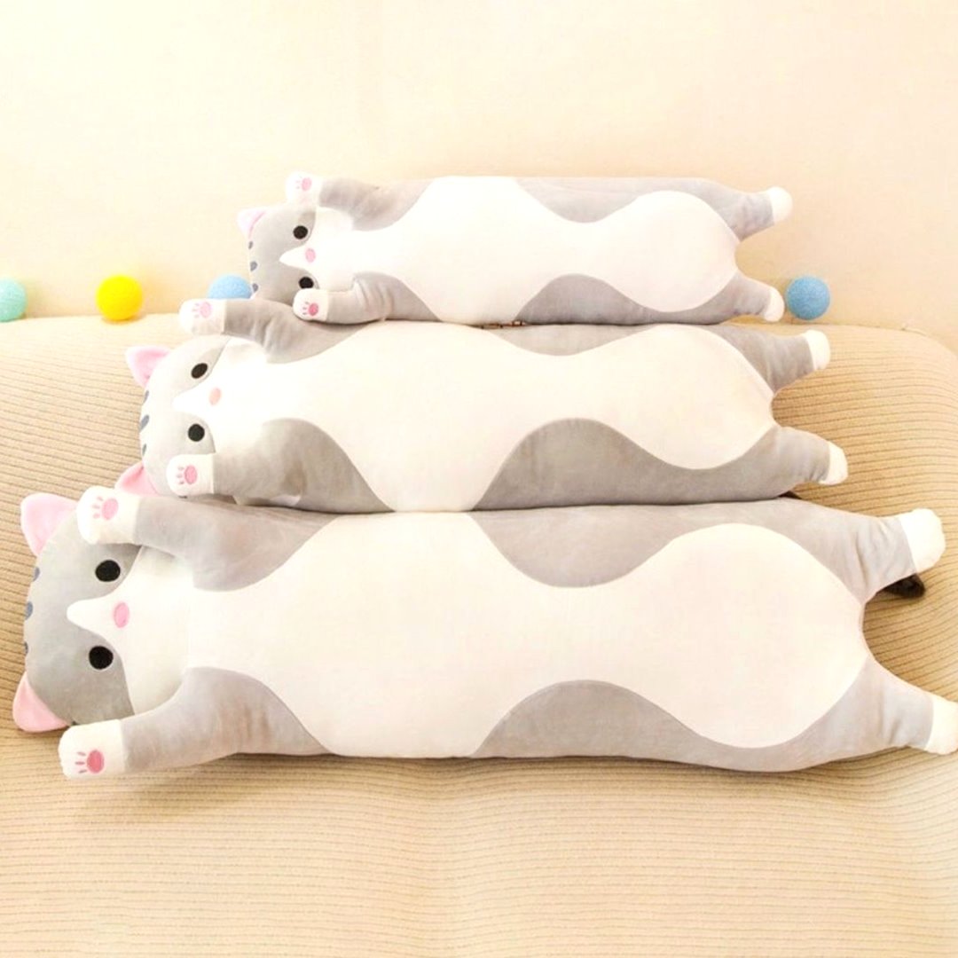Three long gray cat plush toys of varying sizes lying on a sofa, showcasing soft fabric and huggable design, ideal as cuddle buddies or decorative plush.