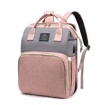Nimbus Tote Diaper Backpack in pink and gray, showcasing its front design. A stylish and practical diaper bag with organized storage.
