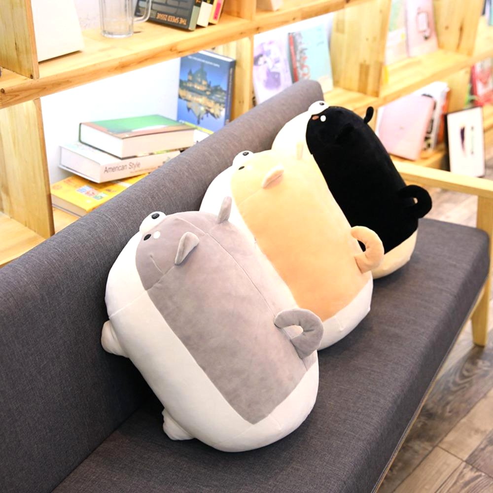 Three Shiba Inu plush toys in black, brown, and grey, made from premium soft fabric, lined up on a grey sofa.