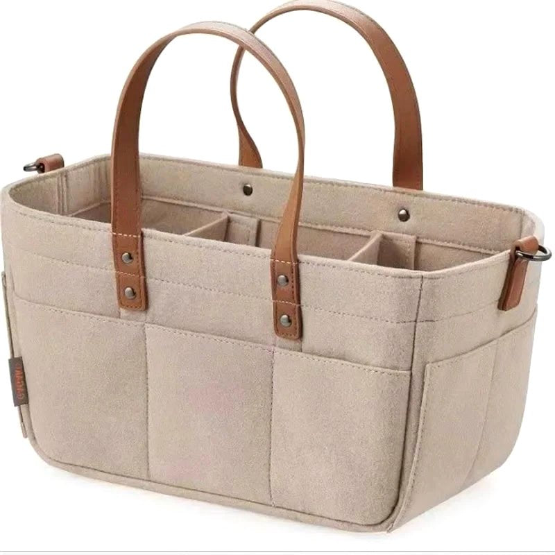 Beige Cloudscape Diaper Tote Bag made of structured felt with brown leather handles, featuring multiple internal compartments and external pockets, shown on a white background.